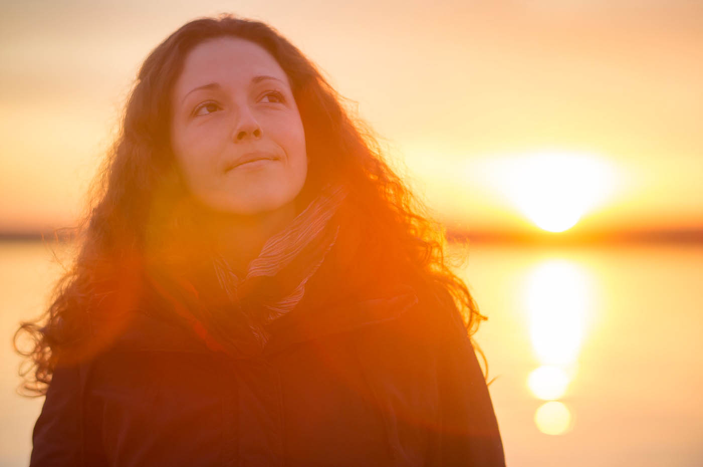 A women standing in front of a red light sunset, learn the benefits of light therapy in Holland.