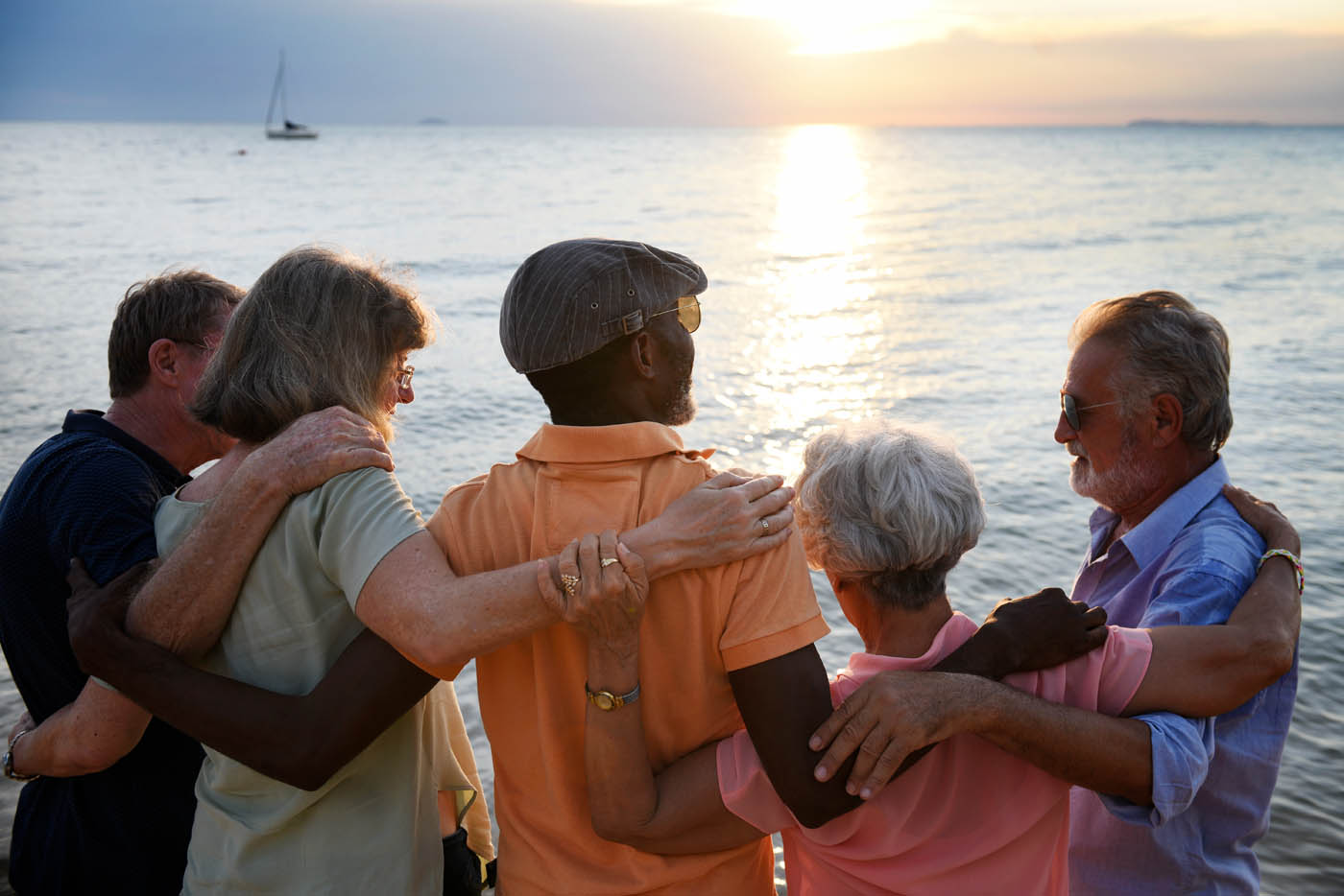 A group of older people watching a sunset at the beach while enjoying the benefits of red light therapy at Light Lounge Holland.